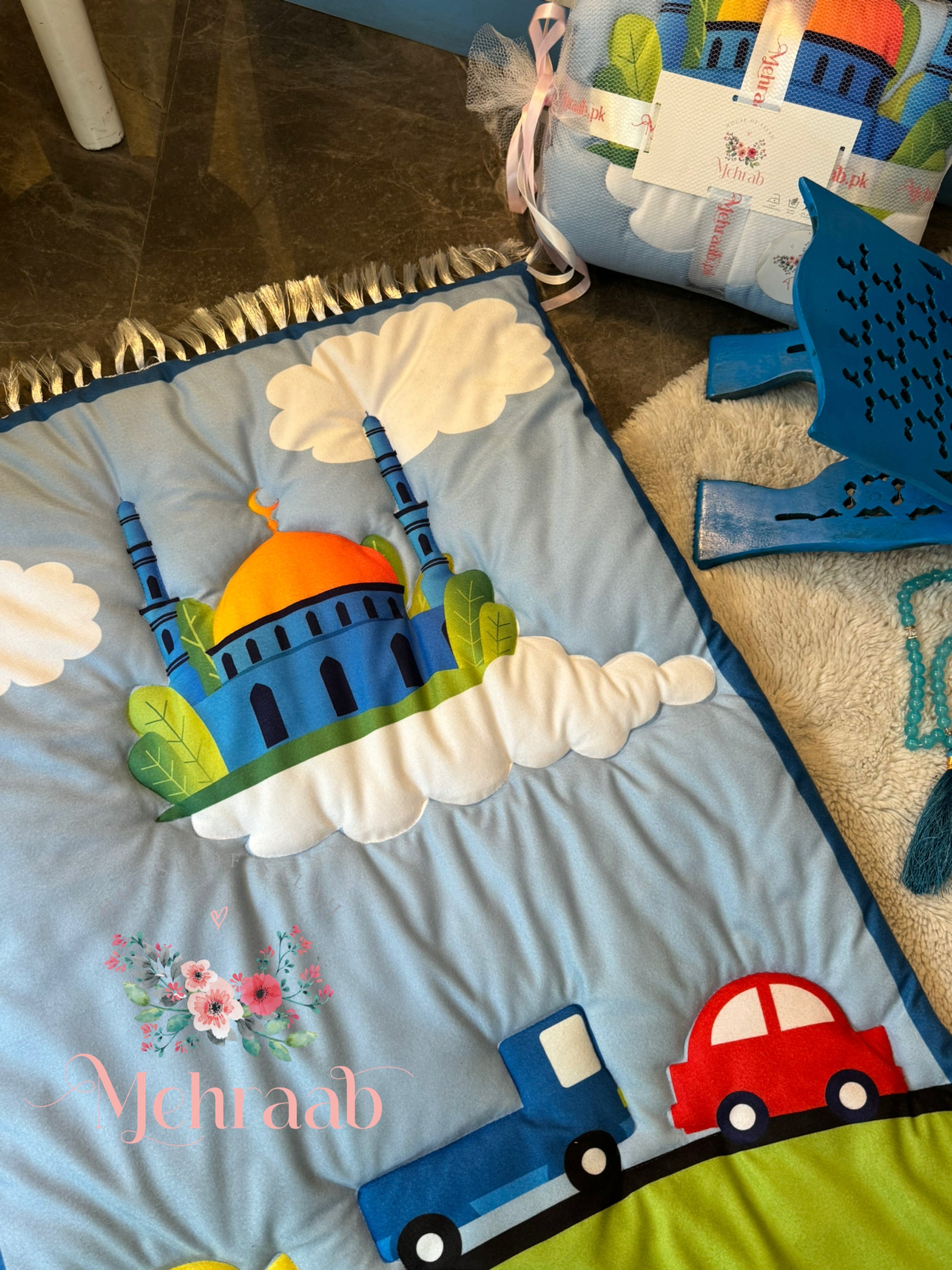 Close up view of sky blue janamaz for kids with cars and mosque illustration